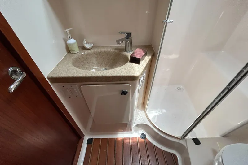 Slide: The Image of 1999 Tiara Yachts 400 Express bathroom with sink, shower, and wooden floor. - 14
