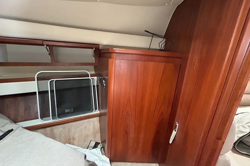 Slide: The Image of 1999 Tiara Yachts 400 Express cabin interior with wooden cabinetry and storage space. - 16