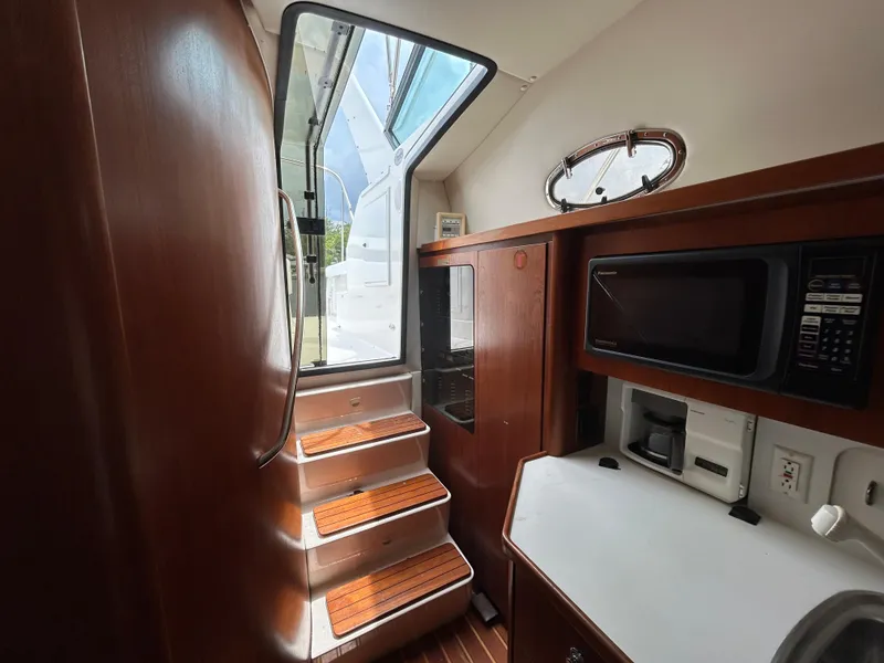 Slide: The Image of Interior of 1999 Tiara Yachts 400 Express, featuring wooden cabinetry and modern appliances. - 21