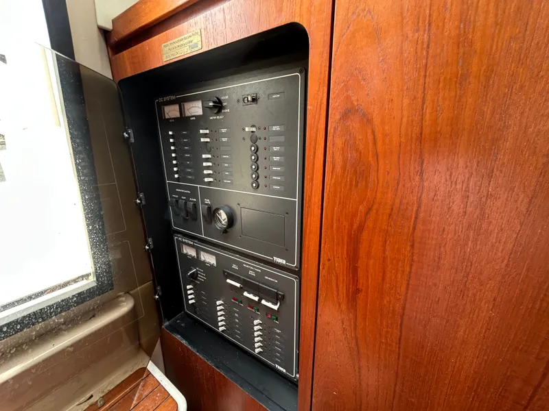 Slide: The Image of Electrical panel on 1999 Tiara Yachts 400 Express with wooden cabinetry. - 22