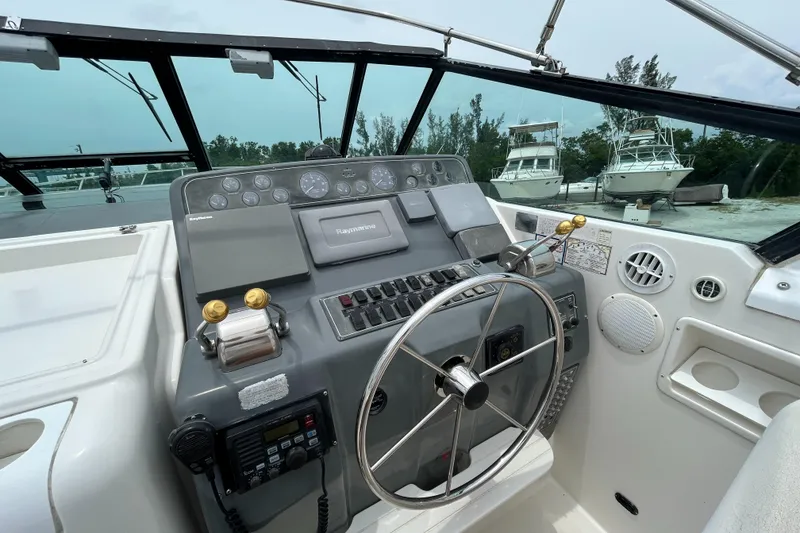 Slide: The Image of 1999 Tiara Yachts 400 Express helm with steering wheel and control panel. - 29