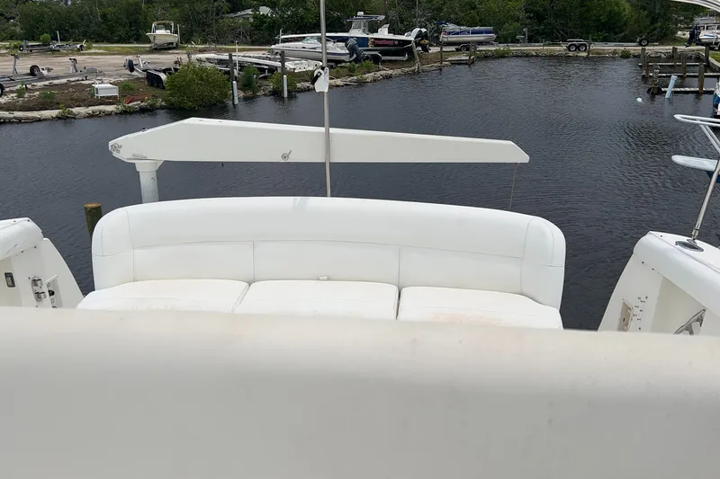Slide: The Image of 1999 Tiara Yachts 400 Express with white seating, docked by a calm marina. - 37