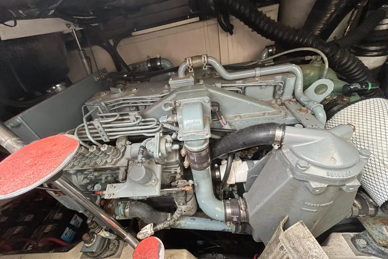 Slide: The Image of Engine compartment of a 1999 Tiara Yachts 400 Express, showcasing mechanical components and hoses. - 43