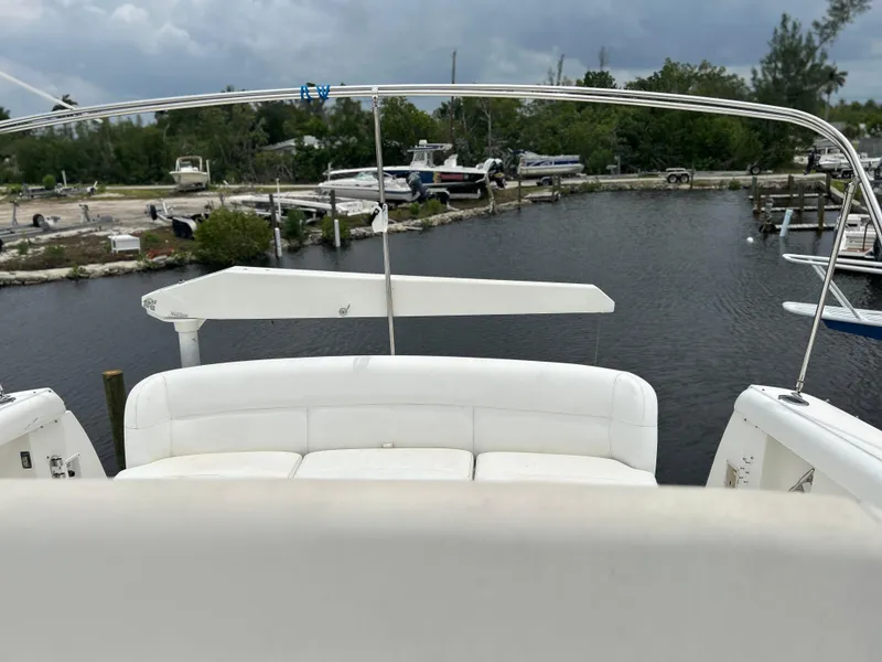 Slide: The Image of 1999 Tiara Yachts 400 Express at a marina, featuring white seating and calm waters. - 8