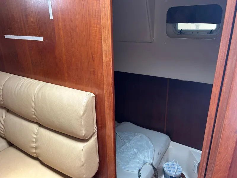 Slide: The Image of 1999 Tiara Yachts 400 Express cabin interior with wood paneling and beige seating. - 9