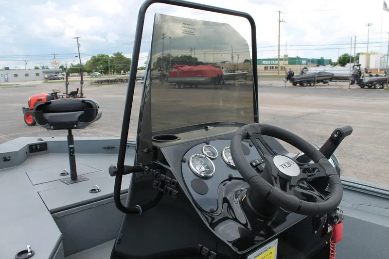 Slide: The Image of 2024 Excel Bay Pro Elite 183 boat dashboard with steering wheel and gauges. - 2