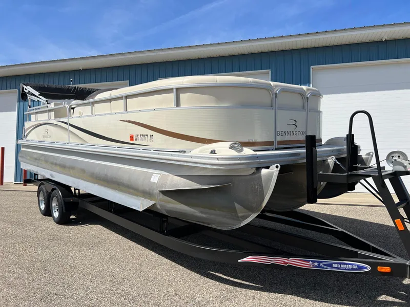 Slide: The Image of 2004 Bennington 2575 RLX pontoon boat on trailer, parked outside a blue building. - 16