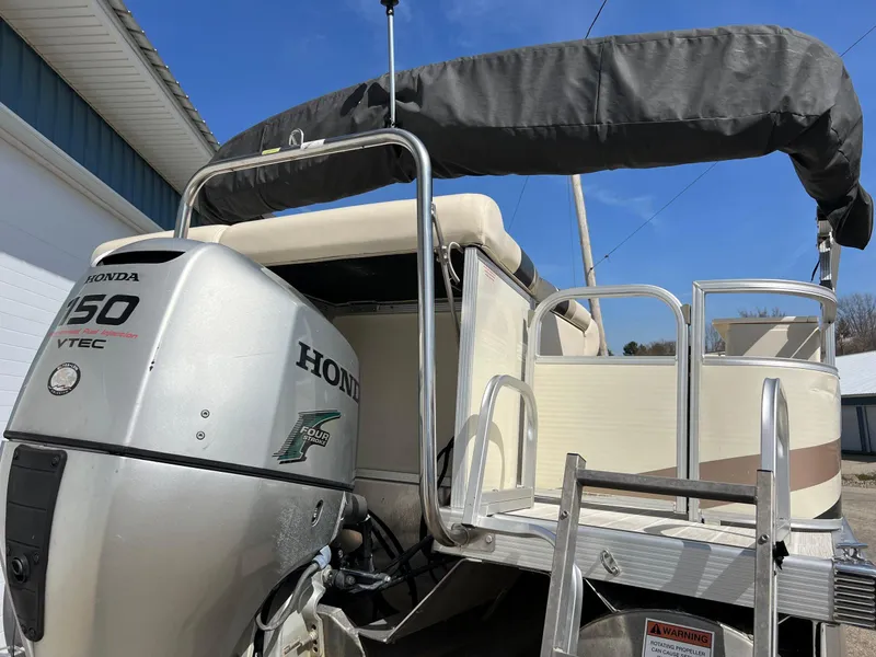 Slide: The Image of 2004 Bennington 2575 RLX pontoon boat with Honda 150 VTEC engine, docked outdoors. - 19