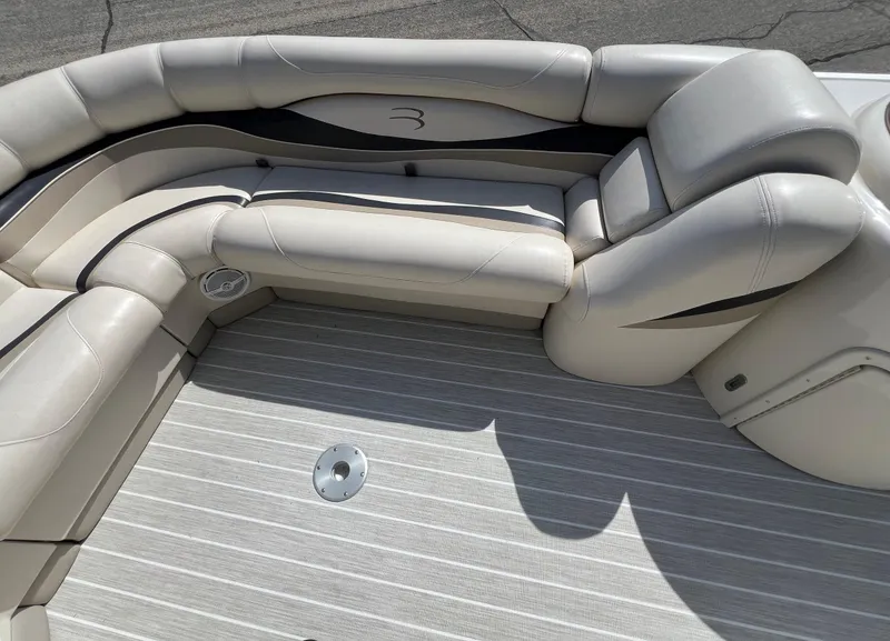 Slide: The Image of 2004 Bennington 2575 RLX boat interior with beige seating and striped flooring. - 22