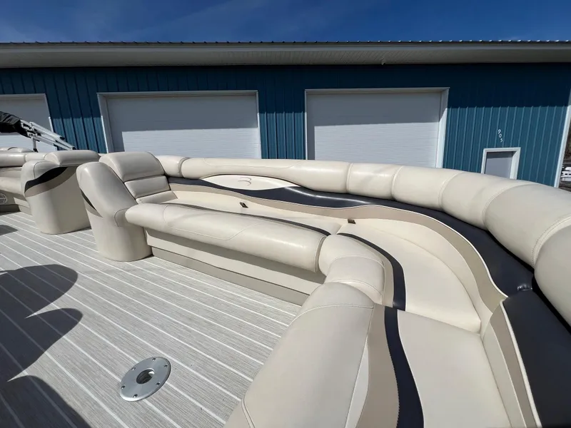 Slide: The Image of 2004 Bennington 2575 RLX boat with beige seating, docked near blue building. - 23