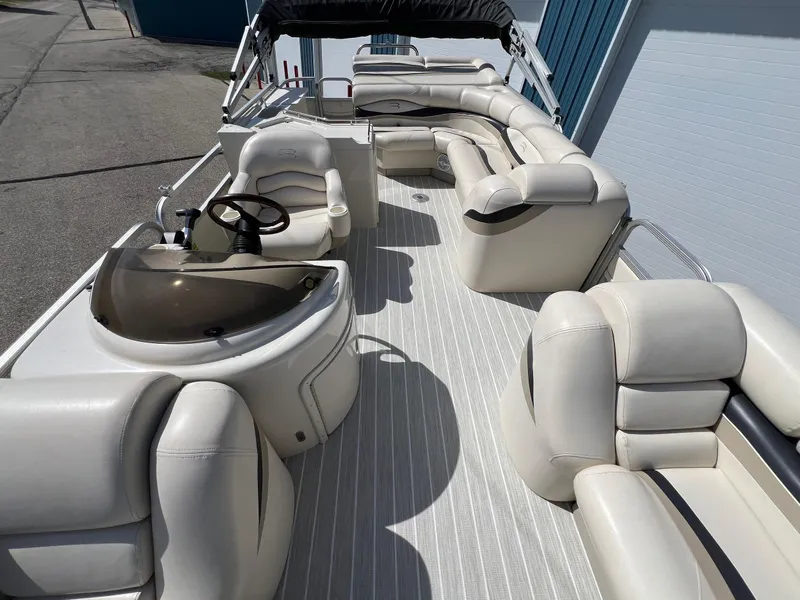 Slide: The Image of 2004 Bennington 2575 RLX pontoon boat with spacious seating and helm, docked outdoors. - 24