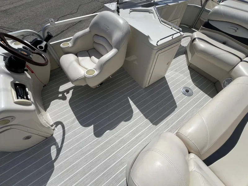 Slide: The Image of 2004 Bennington 2575 RLX boat interior with plush seating and steering wheel. - 26