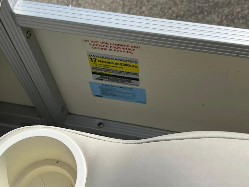 Slide: The Image of 2004 Bennington 2575 RLX boat interior with capacity warning label and cup holder. - 29