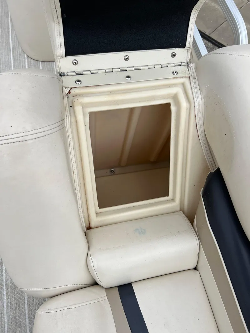 Slide: The Image of 2004 Bennington 2575 RLX boat seat storage compartment, open with beige upholstery. - 3