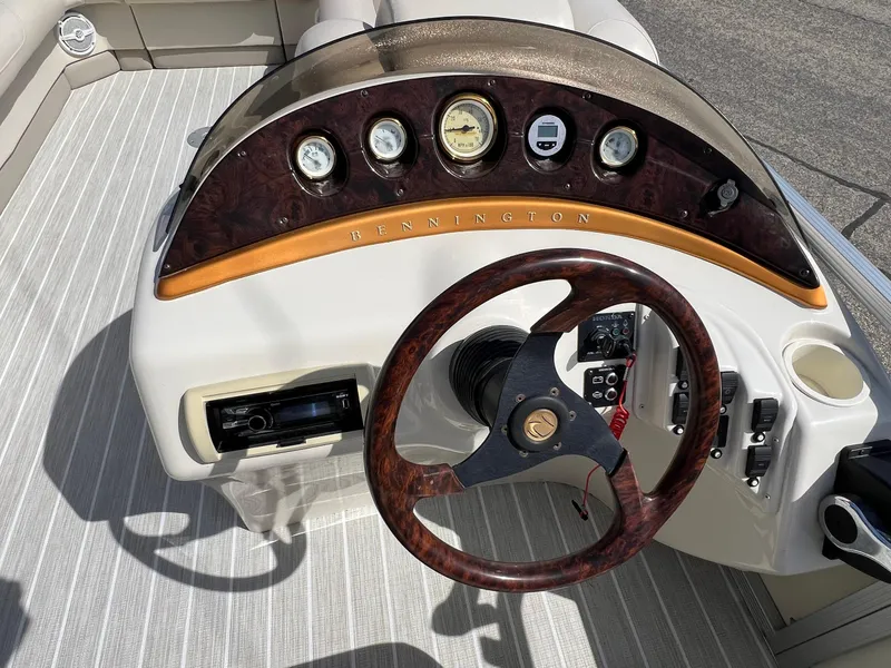 Slide: The Image of Steering console of a 2004 Bennington 2575 RLX boat with wood accents and gauges. - 30