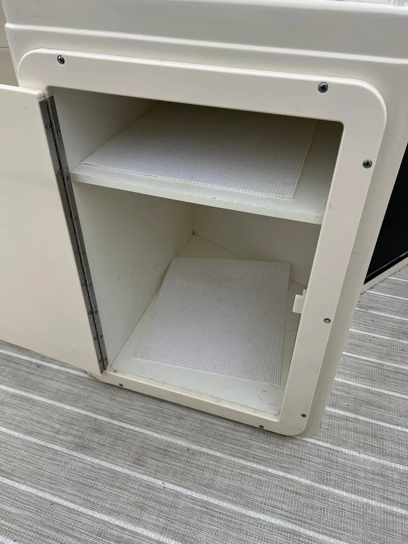Slide: The Image of Open storage compartment on a 2004 Bennington 2575 RLX boat. - 6