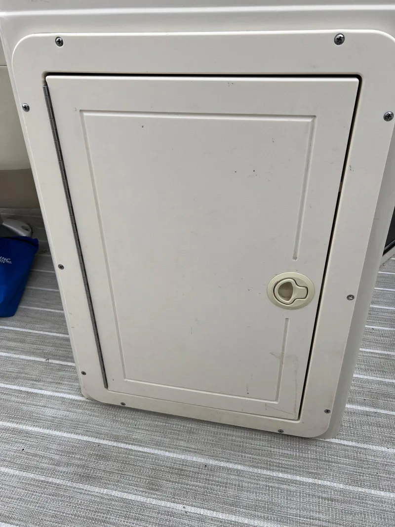 Slide: The Image of White storage compartment door on a 2004 Bennington 2575 RLX boat. - 7