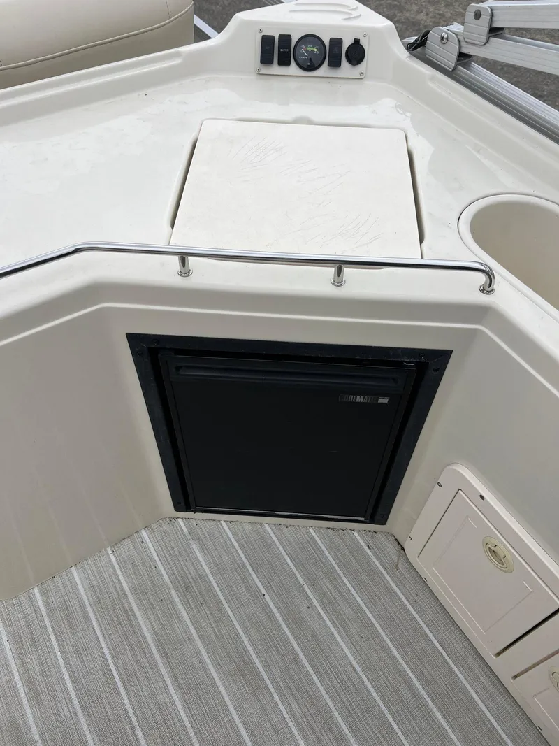 Slide: The Image of 2004 Bennington 2575 RLX boat interior with control panel and storage compartments. - 9