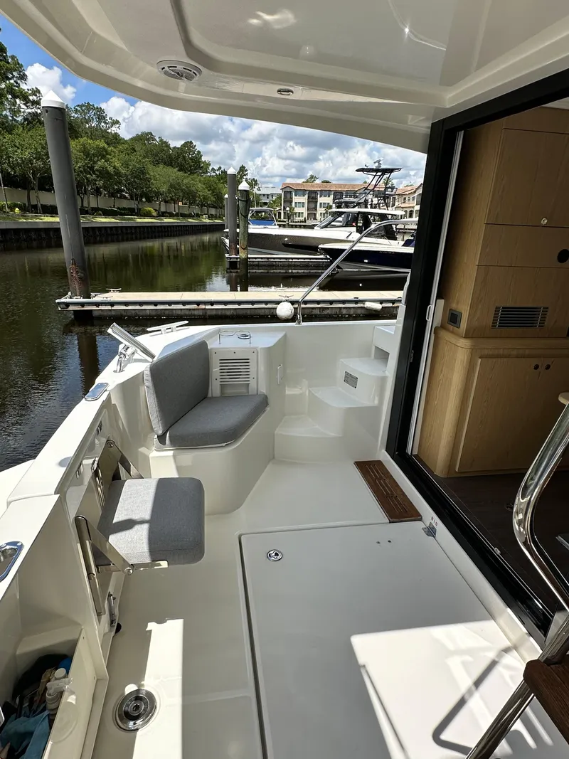 Slide: The Image of 2022 Beneteau Swift Trawler 35, spacious deck with seating, docked at marina. - 15