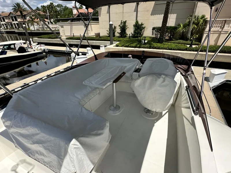 Slide: The Image of Flybridge of 2022 Beneteau Swift Trawler 35 with covered seating and table, docked at marina. - 27
