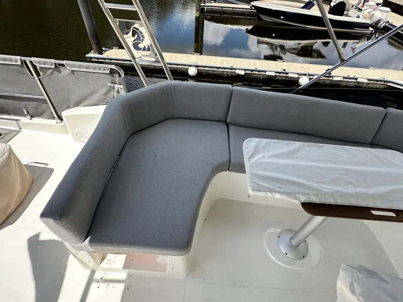 Slide: The Image of Cozy seating area on 2022 Beneteau Swift Trawler 35, docked by the water. - 30