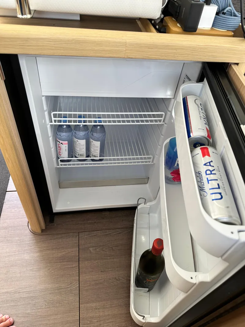 Slide: The Image of Mini fridge inside 2022 Beneteau Swift Trawler 35, stocked with drinks. - 44