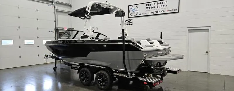 Slide: The Image of 2025 Nautique Super Air Nautique GS20 boat in showroom, black and white design, on trailer. - 3