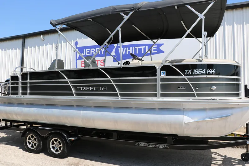 Slide: The Image of 2021 Trifecta 24 RFC pontoon boat with canopy, displayed on a trailer. - 10