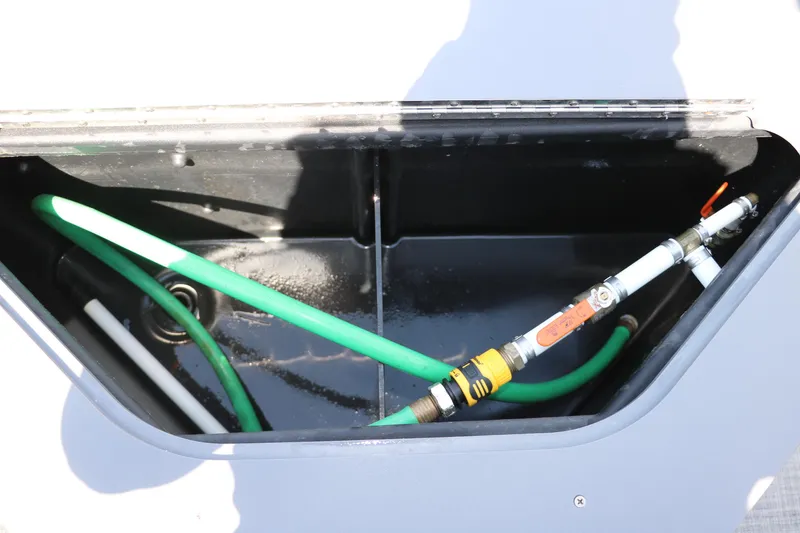 Slide: The Image of Storage compartment with hoses in a 2021 Trifecta 24 RFC boat. - 27