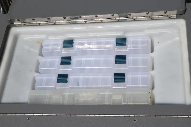 Slide: The Image of Storage compartment with organized containers in a 2021 Trifecta 24 RFC boat. - 28