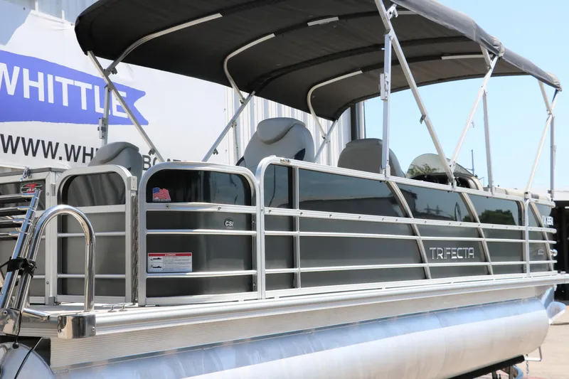Slide: The Image of 2021 Trifecta 24 RFC pontoon boat with canopy, docked outdoors. - 3