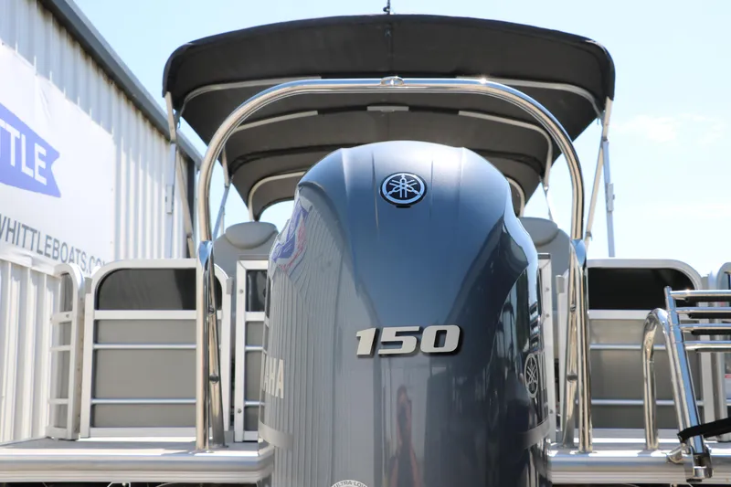 Slide: The Image of 2021 Trifecta 24 RFC pontoon boat with Yamaha 150 engine, docked at marina. - 4