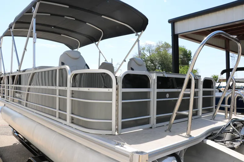 Slide: The Image of 2021 Trifecta 24 RFC pontoon boat with canopy and seating, docked outdoors. - 5