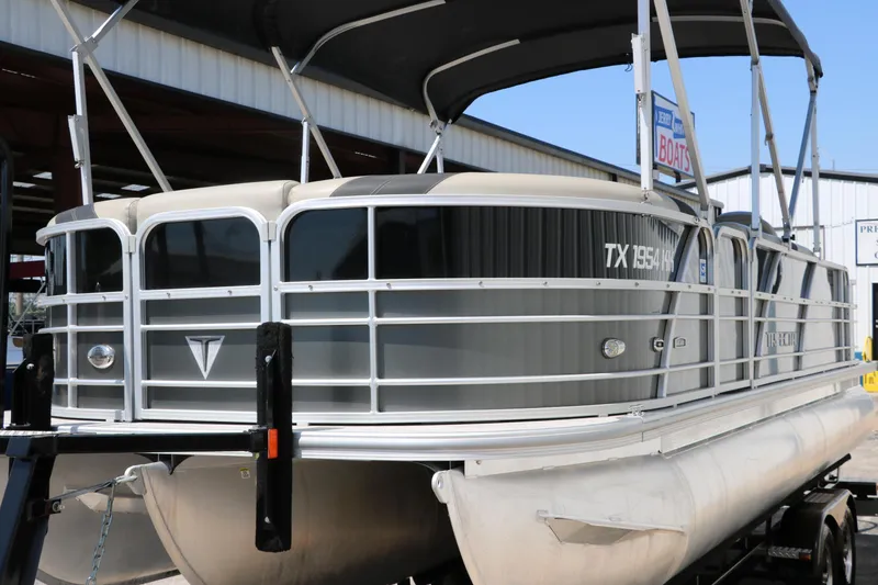 Slide: The Image of 2021 Trifecta 24 RFC pontoon boat with canopy, docked in a marina. - 6