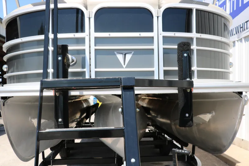 Slide: The Image of 2021 Trifecta 24 RFC pontoon boat front view with ladder and sleek design. - 7