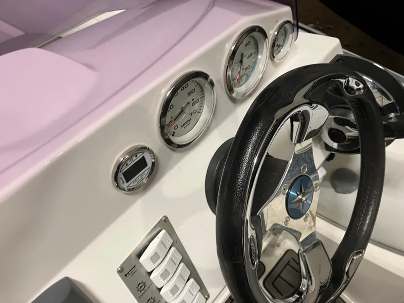 Slide: The Image of Steering wheel and dashboard of 2015 Brig Eagle 480 boat, featuring gauges and controls. - 11