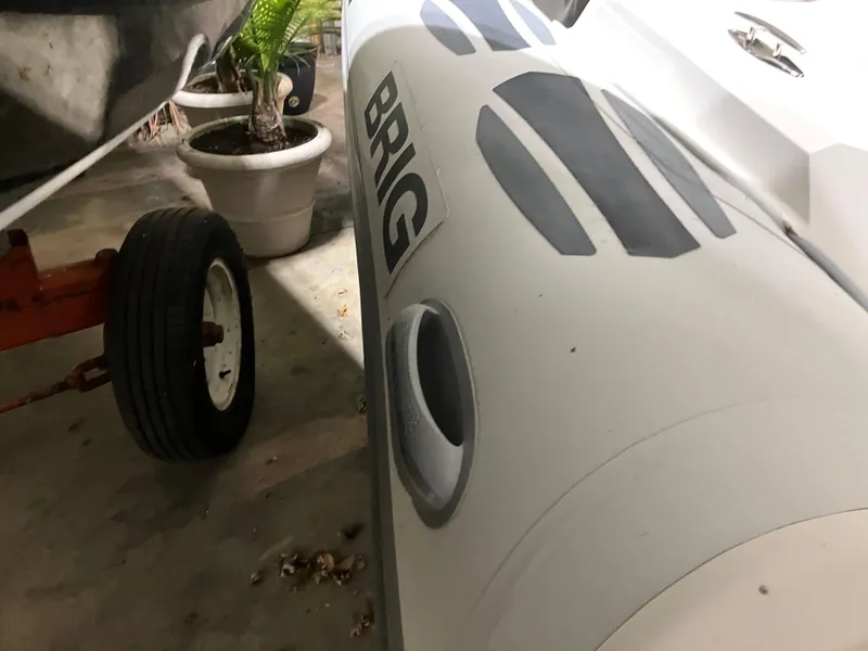 Slide: The Image of 2015 Brig Eagle 480 inflatable boat in garage, near potted plants and trailer wheel. - 18