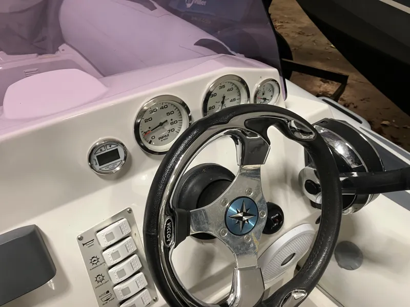 Slide: The Image of Steering wheel and dashboard of 2015 Brig Eagle 480 boat, featuring gauges and controls. - 8