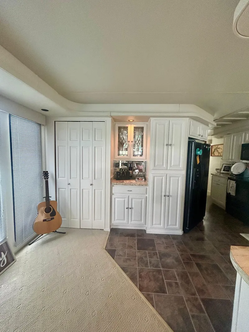 Slide: The Image of Interior of a 2002 Sumerset houseboat with modern kitchen and acoustic guitar. - 10