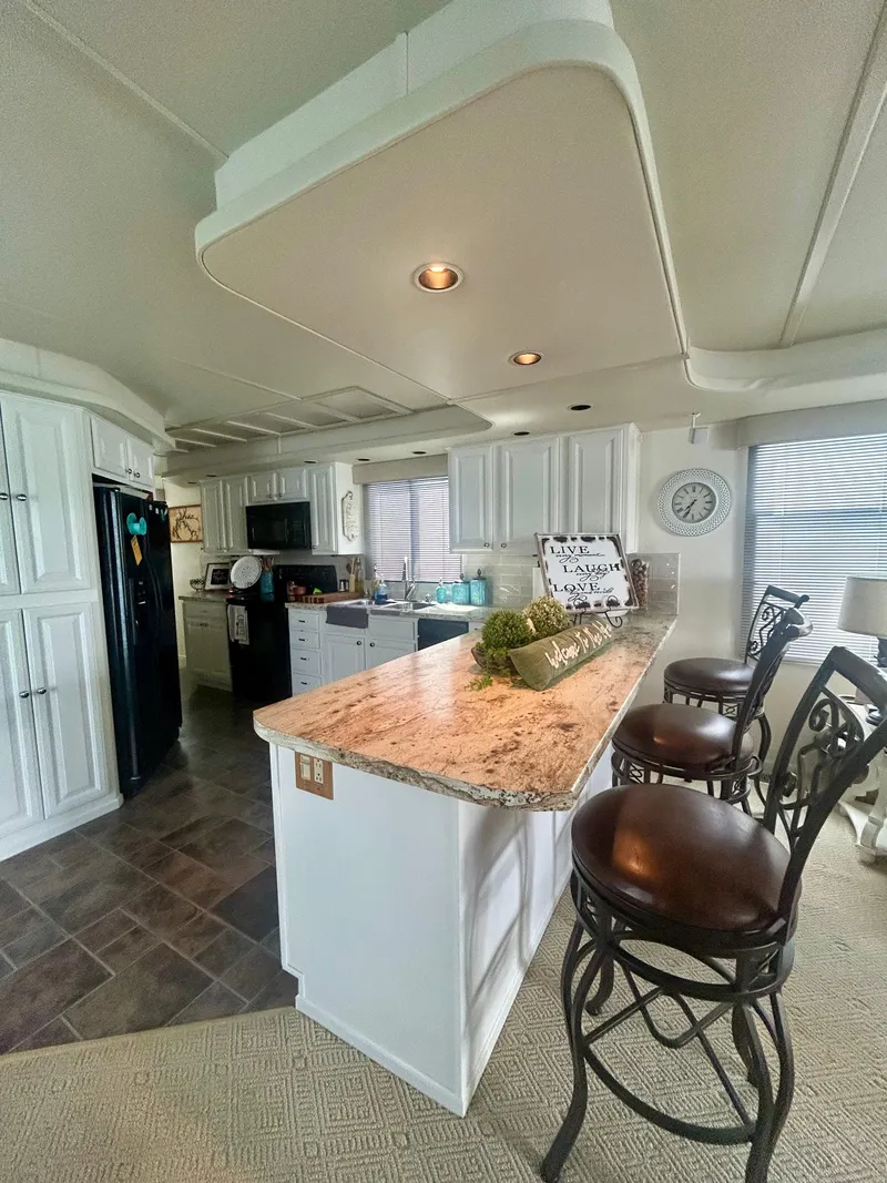 Slide: The Image of Luxurious 2002 Sumerset houseboat kitchen with granite countertops and elegant bar stools. - 12
