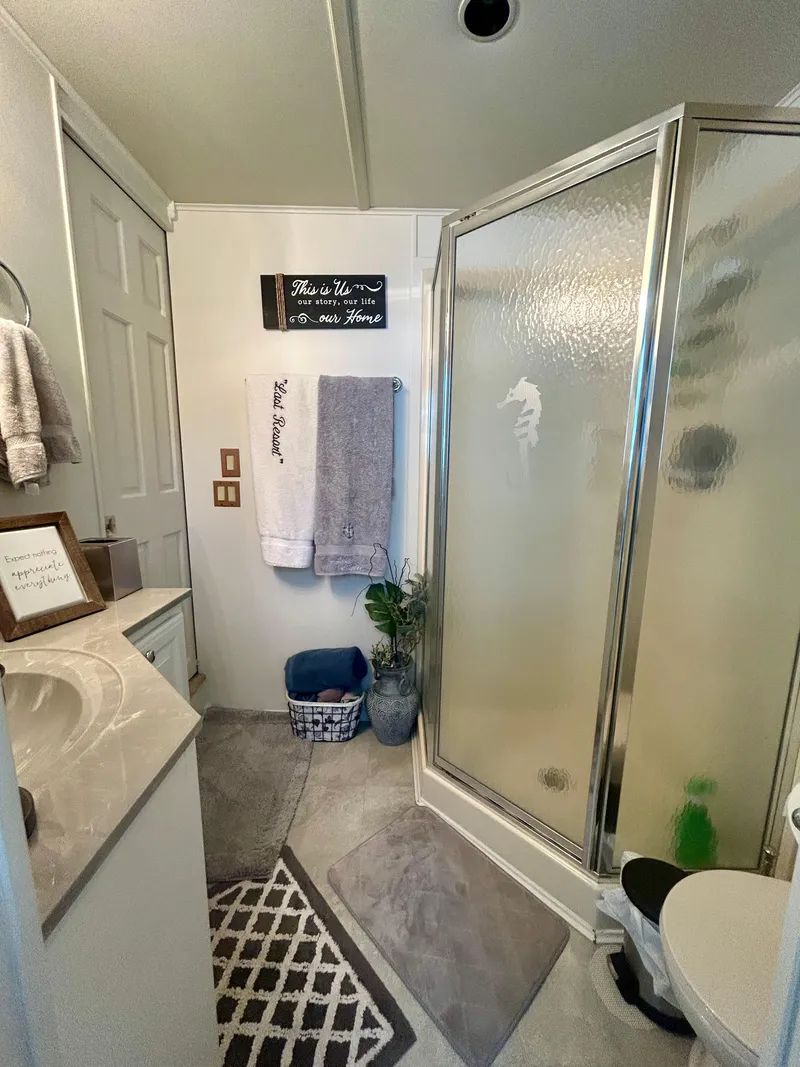 Slide: The Image of 2002 Sumerset houseboat bathroom with shower, towels, and decorative accents. - 18
