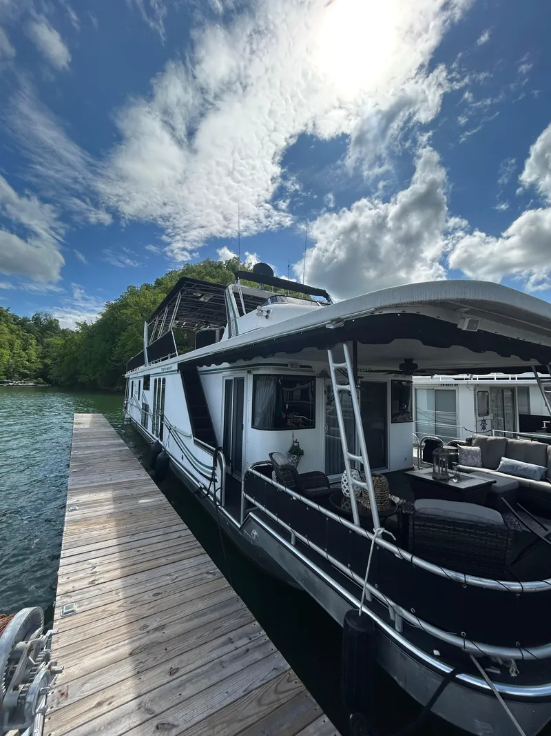 Slide: The Image of 2002 Sumerset houseboat docked under a partly cloudy sky. - 2
