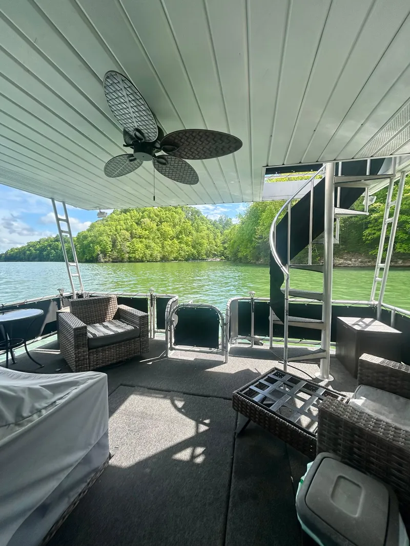 Slide: The Image of 2002 Sumerset houseboat deck with spiral staircase, wicker furniture, and scenic lake view. - 22
