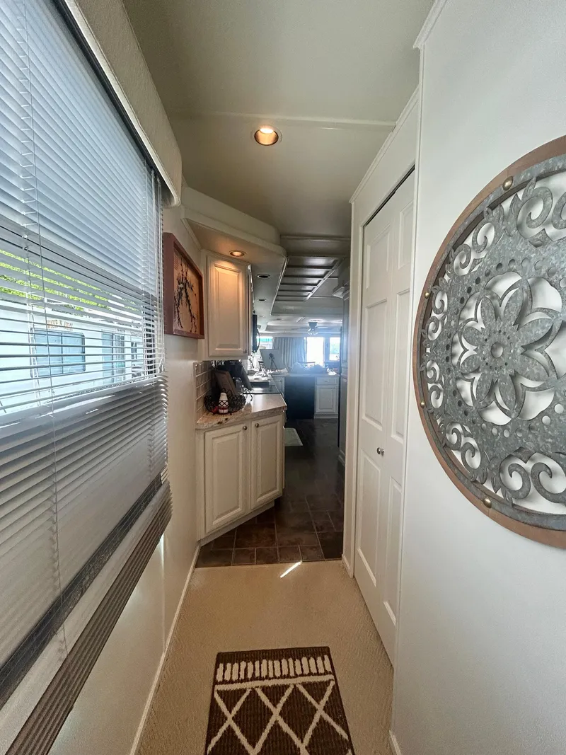 Slide: The Image of Interior hallway of a 2002 Sumerset houseboat with decorative wall art and natural lighting. - 26