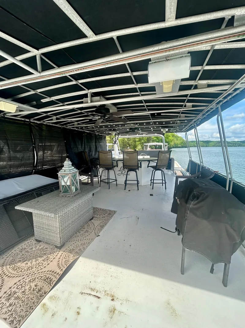 Slide: The Image of 2002 Sumerset houseboat deck with seating, table, and scenic water view. - 29