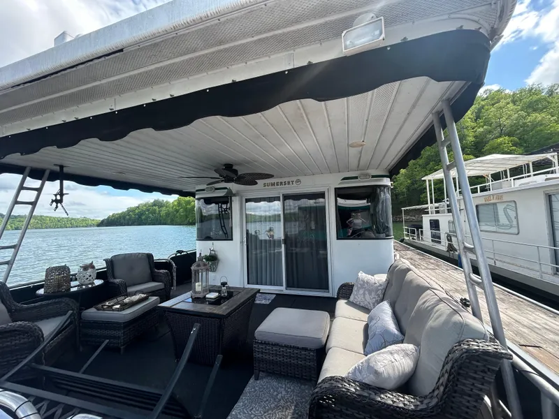 Slide: The Image of 2002 Sumerset houseboat with outdoor seating on a serene lake. - 3