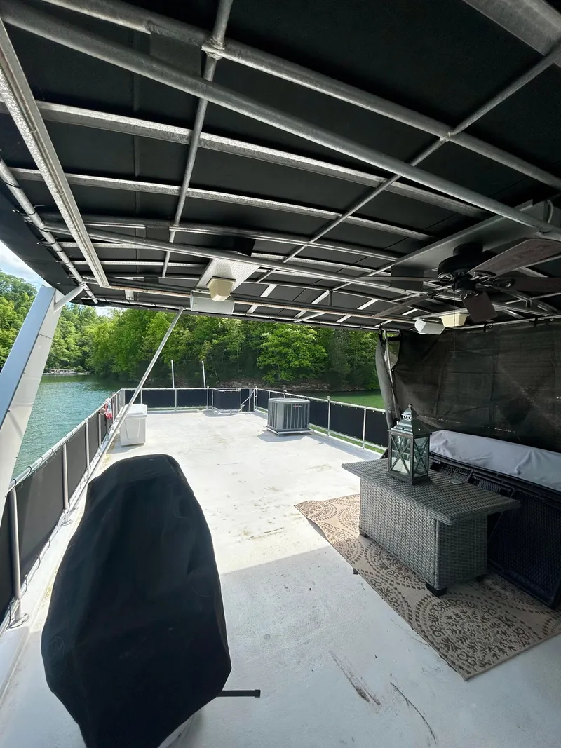 Slide: The Image of 2002 Sumerset houseboat deck with seating, canopy, and scenic water view. - 31