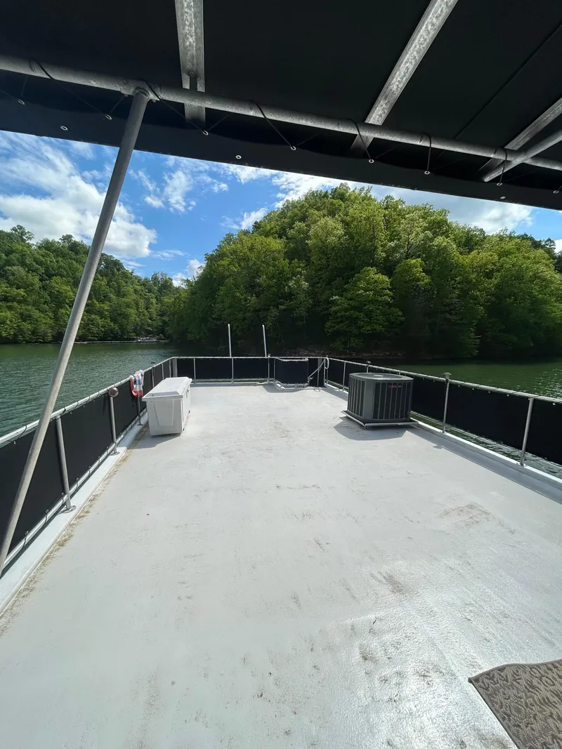 Slide: The Image of 2002 Sumerset houseboat deck with scenic lake and lush greenery. - 32