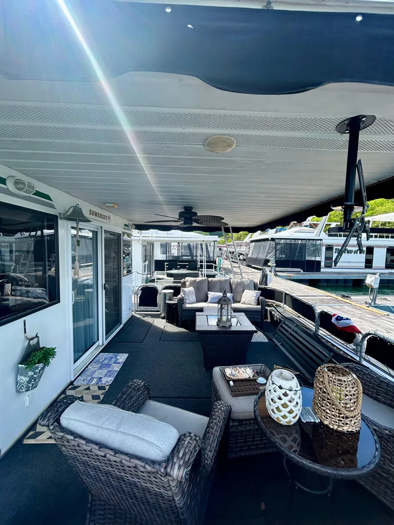 Slide: The Image of 2002 Sumerset houseboat with spacious deck, wicker furniture, and modern decor. - 4