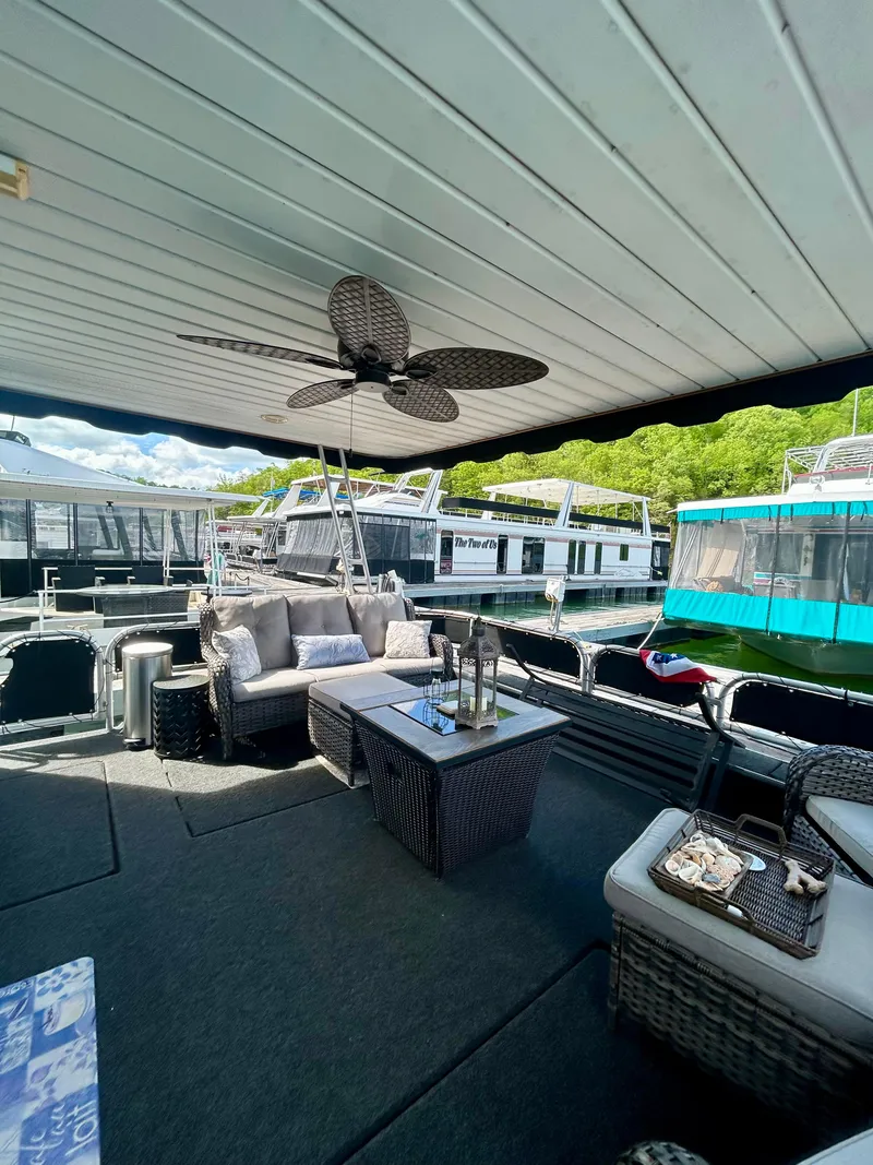 Slide: The Image of 2002 Sumerset houseboat with outdoor seating, ceiling fan, and scenic marina view. - 5